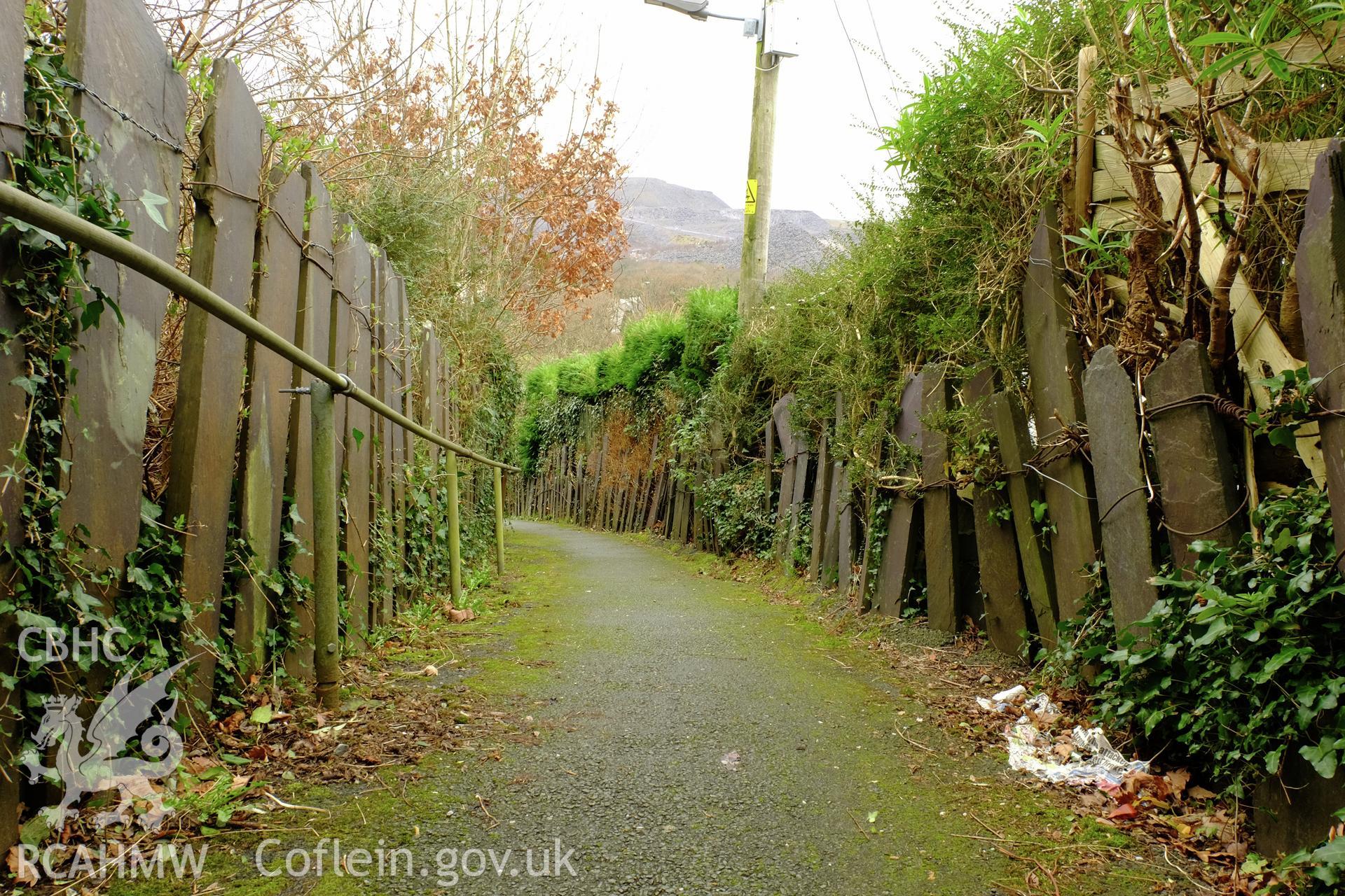 Colour photograph showing view looking south west, showing slate fences on footpath below Well Street, Gerlan, Bethesda, produced by Richard Hayman 16th February 2017