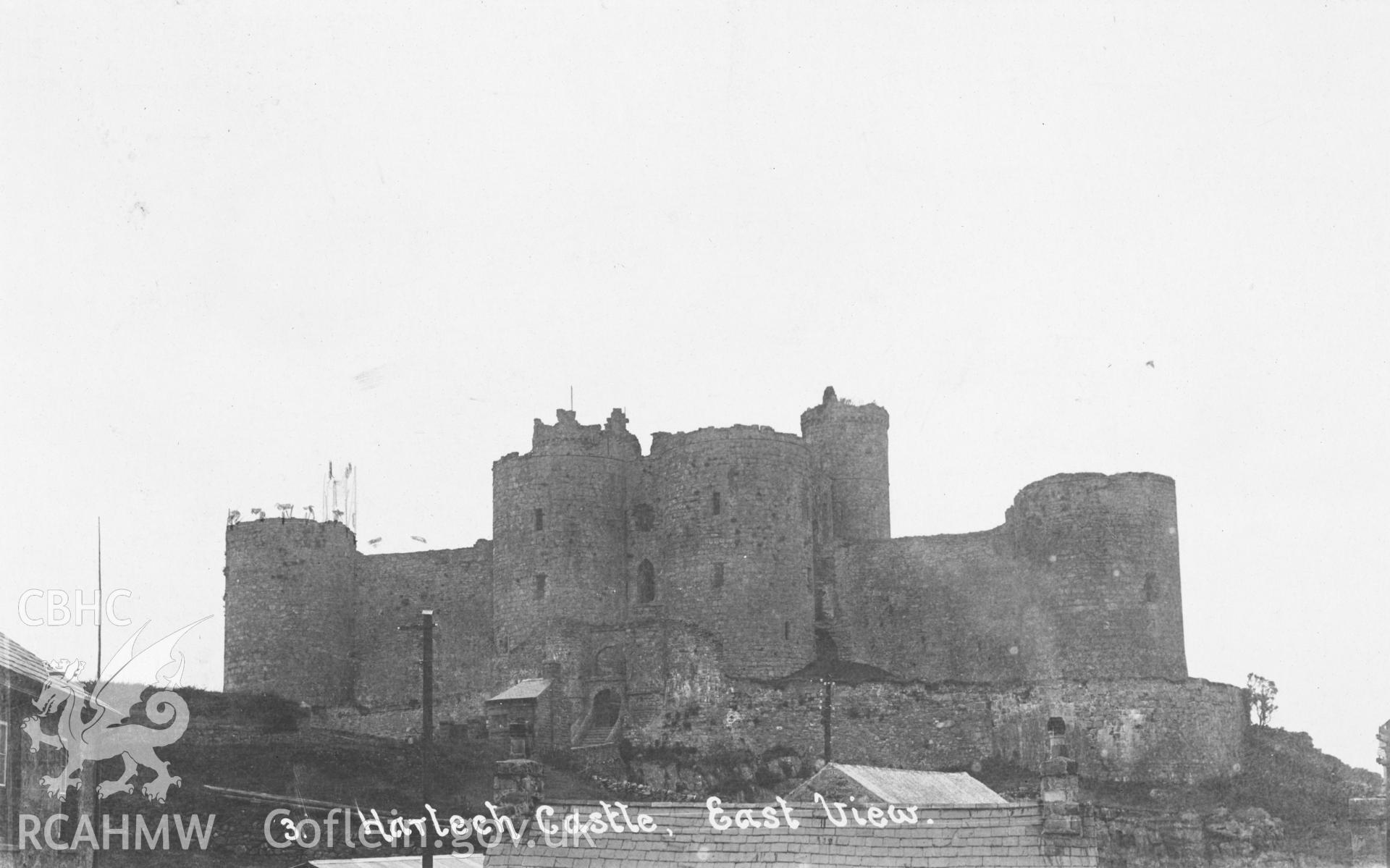 Digital copy of a black and white postcard relating to Harlech Castle: general view from east.