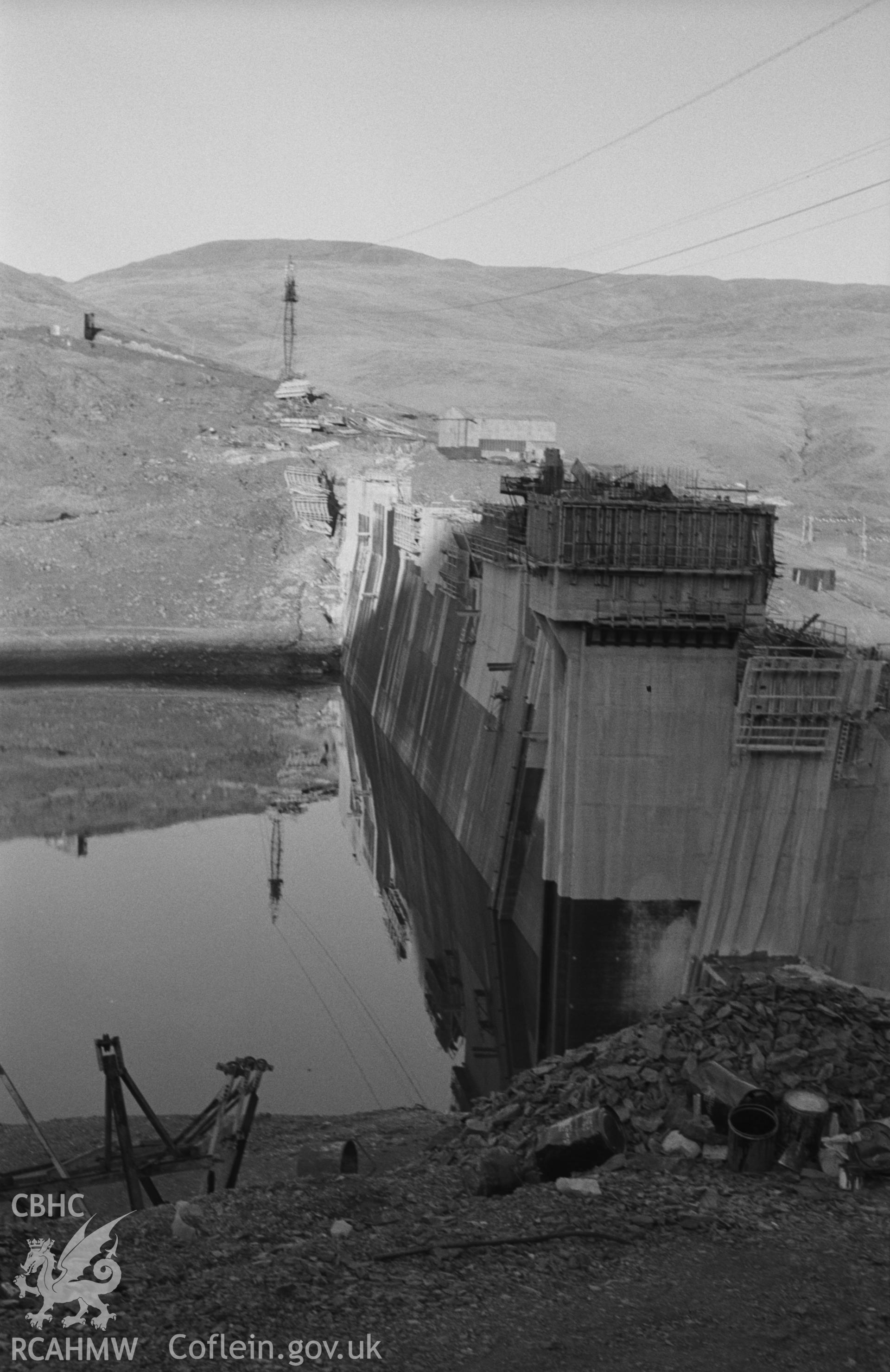 Black and White photograph showing Nant-y-Moch dam under construction. Photographed by Arthur Chater in April 1962 from Grid Reference SN 753 862, looking east.