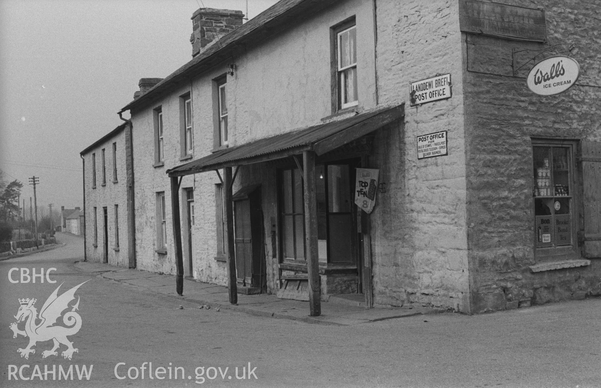 Digital copy of a black and white negative showing the post office at Llanddewi Brefi. Photographed in April 1963 by Arthur O. Chater from Grid Reference SN 6631 5529, looking west.
