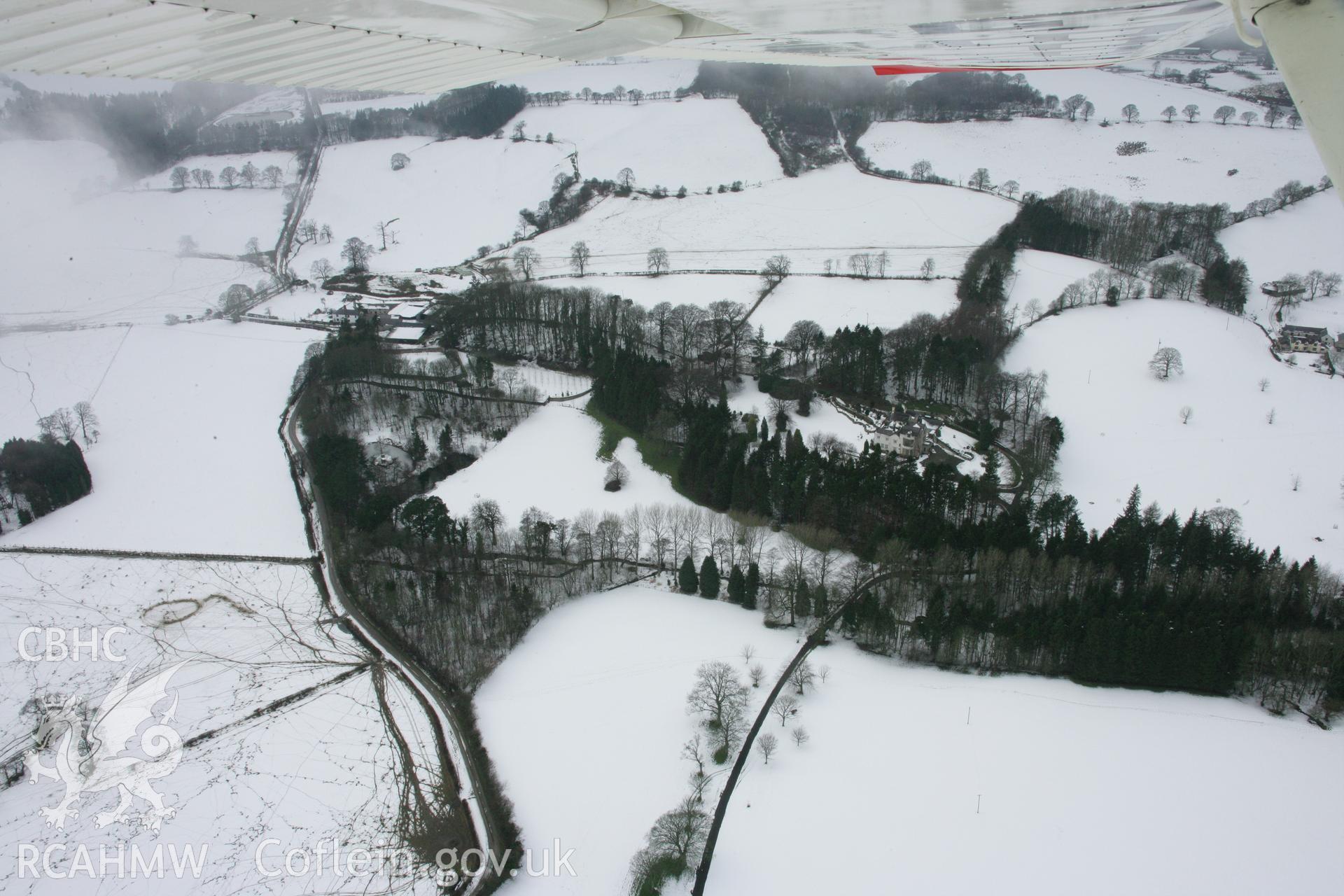 RCAHMW colour oblique aerial photograph of Gelli-Gynan Hall and park, Llanarmon-yn-Ial. A view from the east under snow. Taken on 06 March 2006 by Toby Driver.